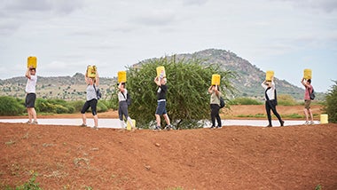 Global Angels volunteers carrying jerry cans