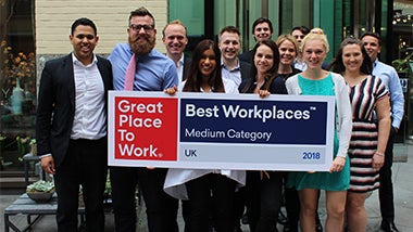 Robert Walters and Walters People UK staff hold up Great Place To Work Best Workplaces Medium Category banner